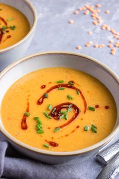 two bowls filled with soup on top of a table