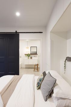 a bedroom with white walls and black doors