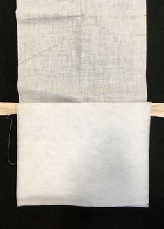 two pieces of white fabric are being sewn together