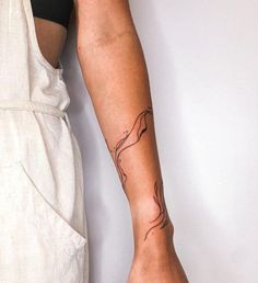 a woman's arm with a tattoo on it and an apron underneath her leg