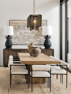 a dining room table with chairs and lamps