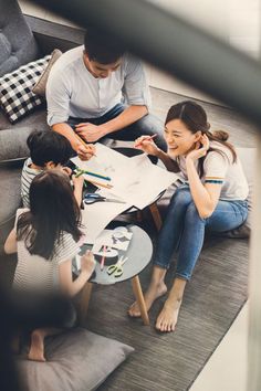 three people are sitting on the floor and one person is talking on her cell phone