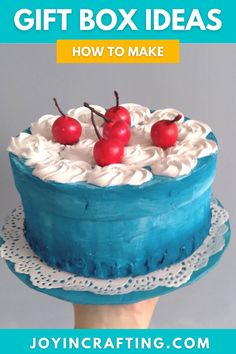 a blue cake with cherries on top and the words gift box ideas how to make