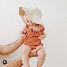 a man holding a baby wearing a hat