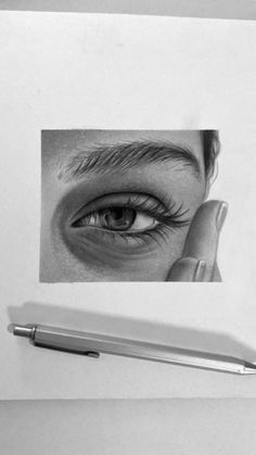 a pencil drawing of a person's eye with their hand on top of it