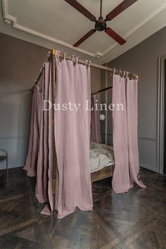 the canopy bed is made up with pink linens