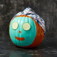 an orange and blue pumpkin with a face painted on it