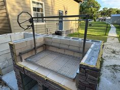 an outdoor grill made out of cinder blocks in front of a house that is under construction