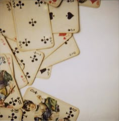 a pile of playing cards sitting on top of a white table next to each other