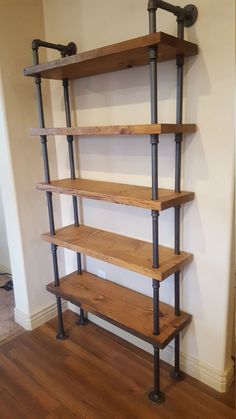 an industrial style shelving unit with four shelves and two pipes on the bottom shelf