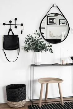 a living room with white walls and black rugs on the floor, two round mirrors hanging from the wall