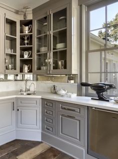 a kitchen filled with lots of cabinets and counter top space next to a wooden floor