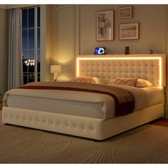 a bedroom with a large bed and lights on the headboard