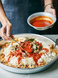 a person holding a spoon over a plate of food