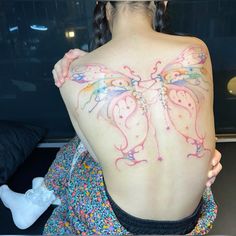 a woman with a butterfly tattoo on her back