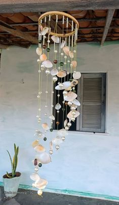 a wind chime hanging from the ceiling next to a potted plant