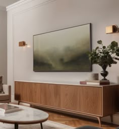 a living room filled with furniture and a painting hanging on the wall above it's coffee table