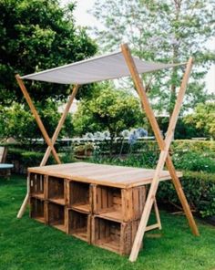 a wooden bench with shelves underneath it in the grass