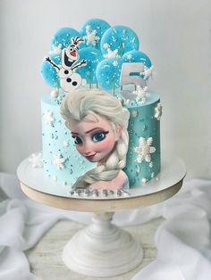 a frozen princess cake with blue frosting and balloons