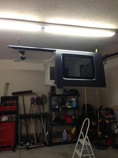 a television mounted to the ceiling in a garage