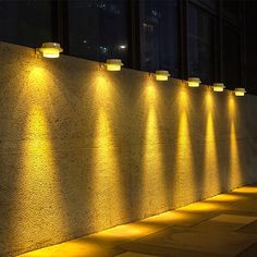 a row of lights that are on the side of a wall next to a building