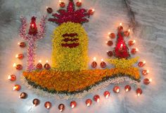 an arrangement of flowers and candles on a white surface with the words happy diwal written in red