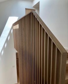 an empty room with wooden stairs and hard wood flooring on the bottom part of the staircase