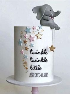 a white cake decorated with stars and an elephant on top that says twinkle twinkle little star