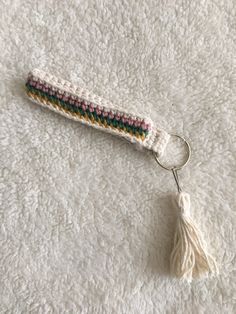 a crocheted keychain with a tassel hanging from it's end