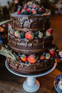 a triple layer chocolate cake with fresh berries on top