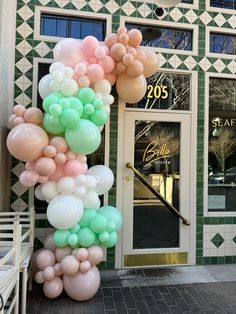 a bunch of balloons that are on the side of a building in front of a door