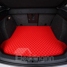 the trunk area of a car with an all - weather floor mat in red and black