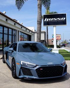 a blue sports car parked in front of a building