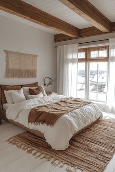 a large bed sitting in the middle of a bedroom next to a window with curtains