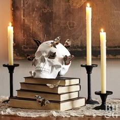 a skull sitting on top of books next to candles