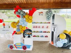 balloons and race cars are on display under the tent