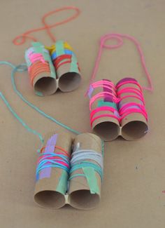 three rolled up paper tubes are sitting on the ground next to some string and scissors