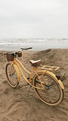 an old bicycle is parked on the beach