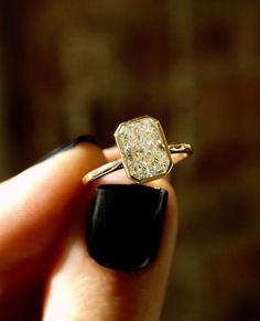 a close up of a person holding a ring with a diamond in it's middle