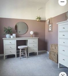 a white dresser sitting next to a mirror on top of a wooden cabinet in a room