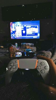 a person holding a video game controller in front of a tv