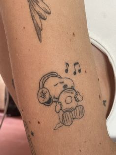 a woman with a tattoo on her leg has a teddy bear and music notes drawn on it