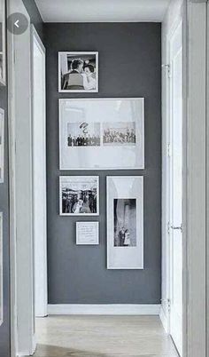 a hallway with pictures on the wall and photos hanging on the wall, along with an open door