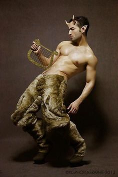 a shirtless man is holding a harp