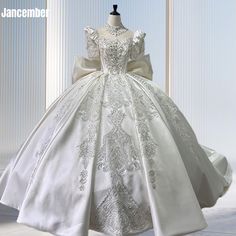 a white wedding dress on display in front of a window with the words janeembie written below it