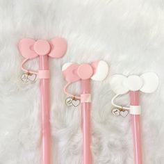 three pink and white heart shaped pens with hearts on the top, one in the middle