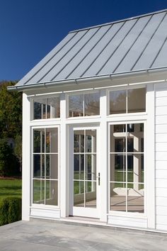 a white house with large windows and a metal roof