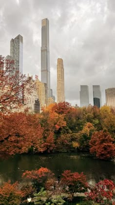 the city skyline is covered in autumn foliage and trees with orange leaves on them, as well as tall skyscrapers