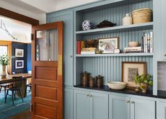 a dining room with blue walls and wooden shelves