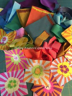 several colorful paper umbrellas are on a cutting board and ready to be sewn